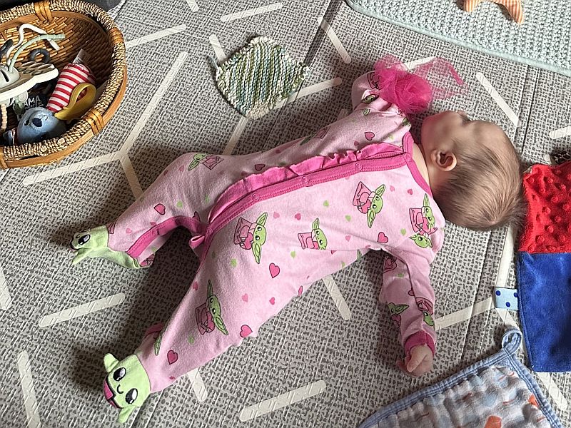 Infant lying on floor.