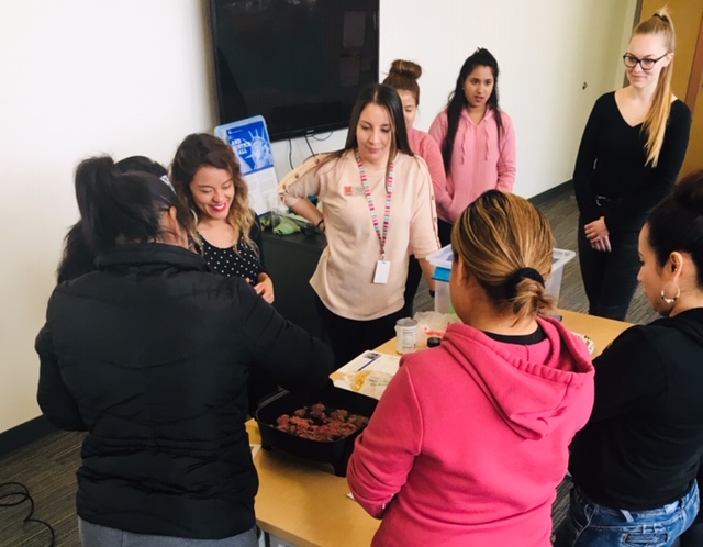 A group of women watching a cooking demonstration.