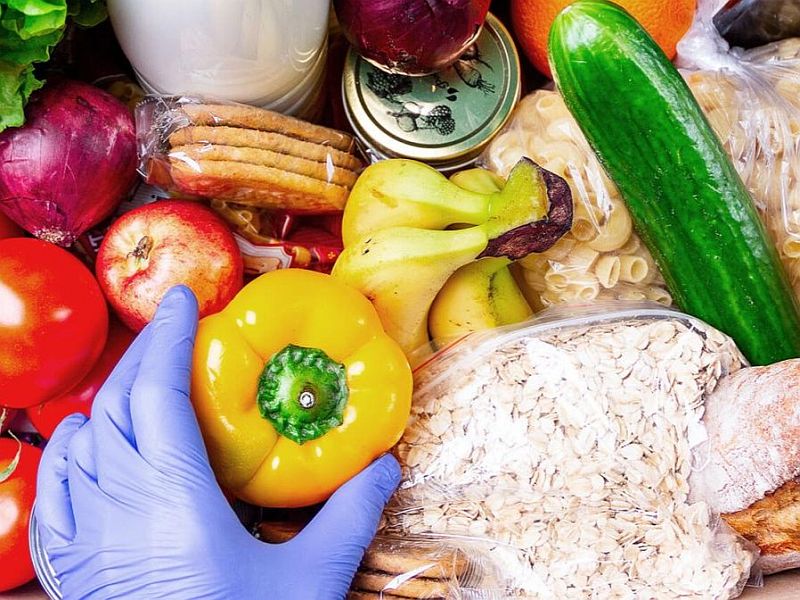 Image of fruits, vegetables, oats, pasta, a canning jar, and a gloved hand holding a yellow pepper.