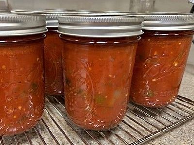 Jars of salsa on a metal rack.