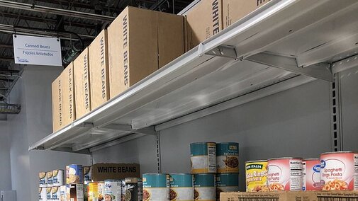 Shelves of can goods and boxes in a food pantry.