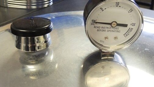 Image of a pressure canner lid with gauge.